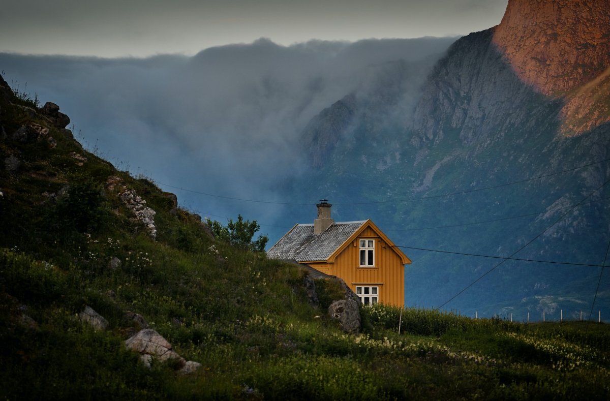 Gammelt gult hus i et øde fjellandskap