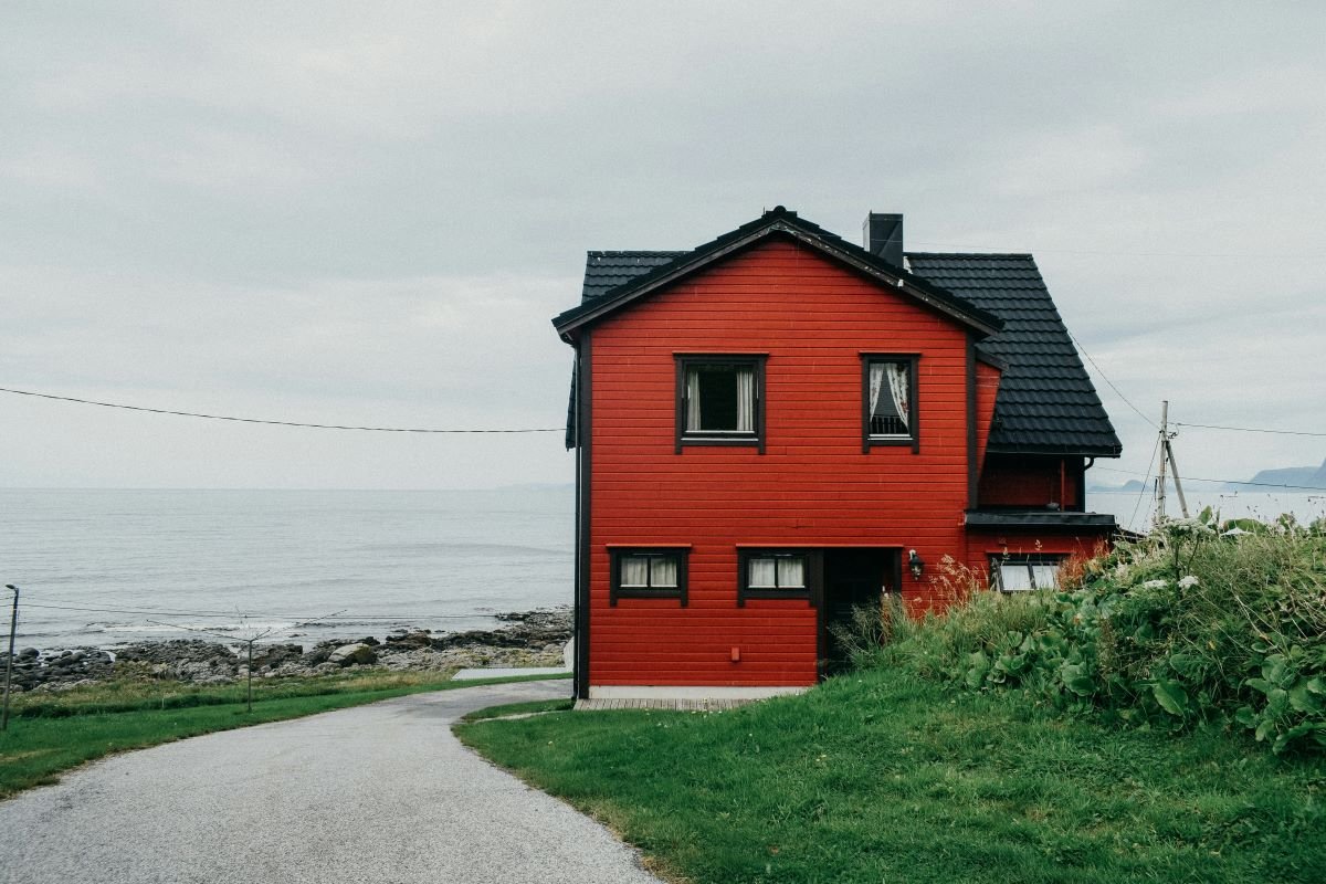 Rød enebolig på en en ensom vei langs kysten