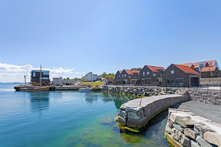 Dalaneset boliger langs brygge, blå sjø og himmel